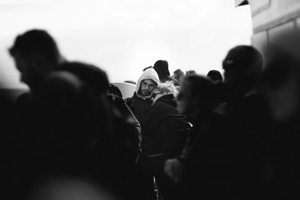 A person sitting in front of a laptop with a chat window open, looking at a photo of a loved one, symbolizing the use of AI for grief support