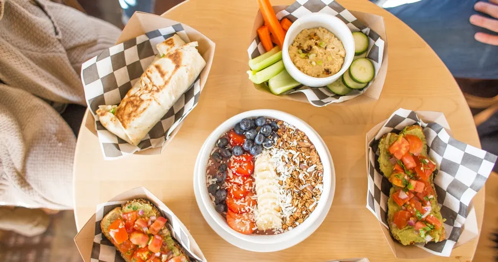 A photo of a scientist in a lab coat holding a tray of French fries, with a background of various cooking equipment and ingredients
