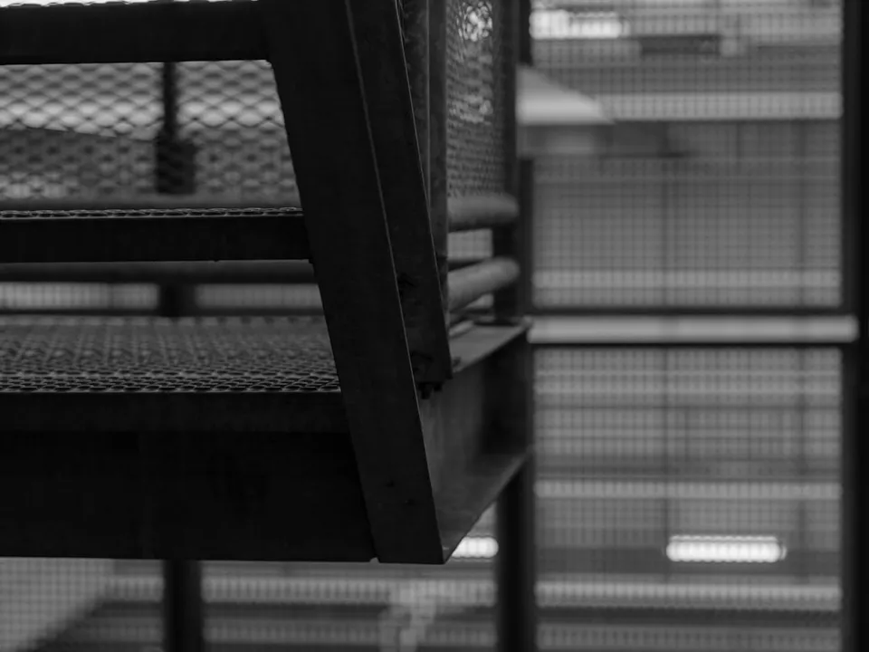 A photo of a person standing in front of a large screen displaying Nvidia's logo, with a cityscape in the background, symbolizing the company's growing presence in the tech industry.